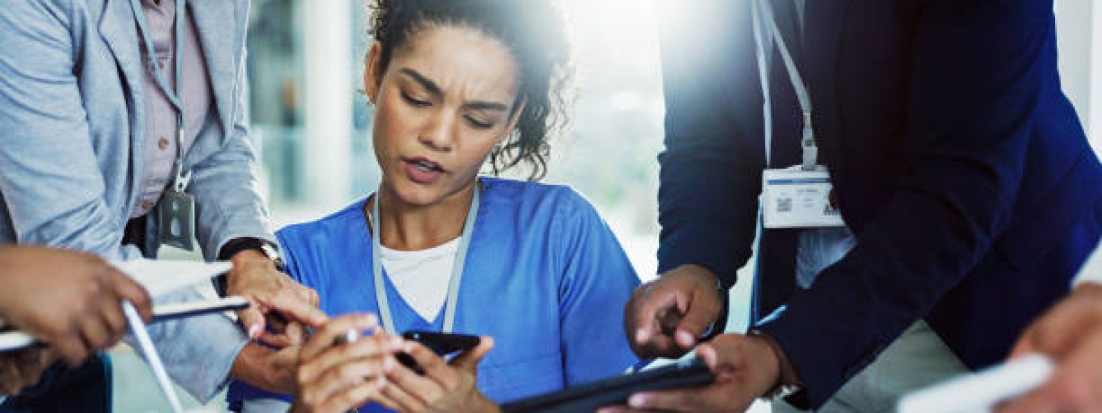 Frustrated woman, nurse and multitasking with team for overworked pressure or chaos at busy hospital. Female person, healthcare employee or demanding colleagues with technology for workload stress